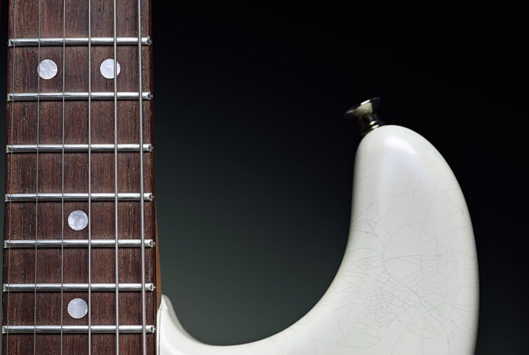A white guitar with a black pickguard.